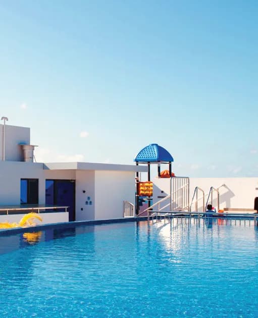 A finished swimming pool with a slide and pool deck.