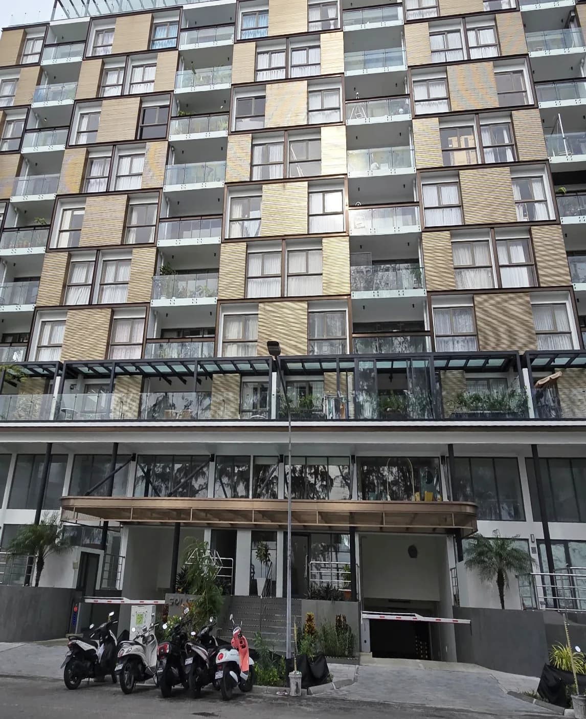 Photograph of Solitaire, a residential building in Malé with glazed balconies and timber-textured cladding panels.