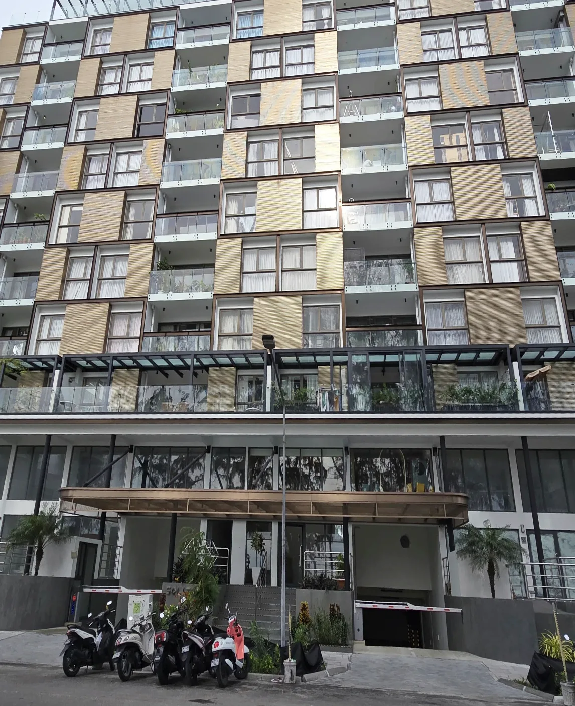 Photograph of Solitaire, a residential building in Malé with glazed balconies and timber-textured cladding panels.