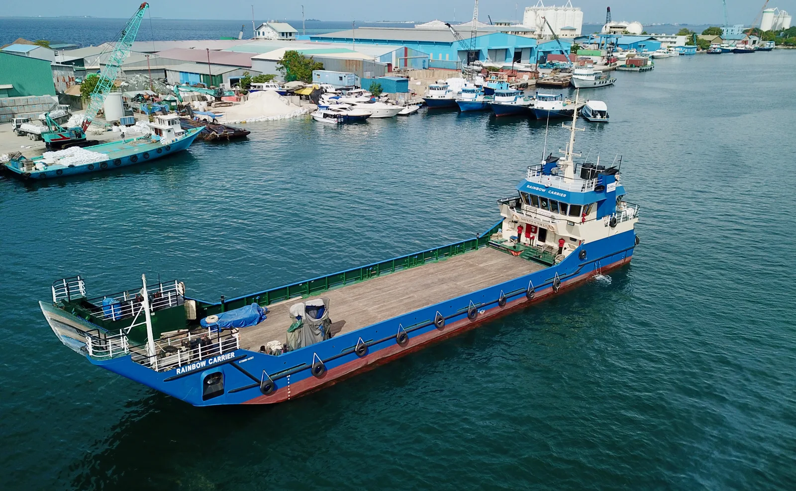 Rainbow Carrier, a blue-hulled landing craft, alongside in harbour.